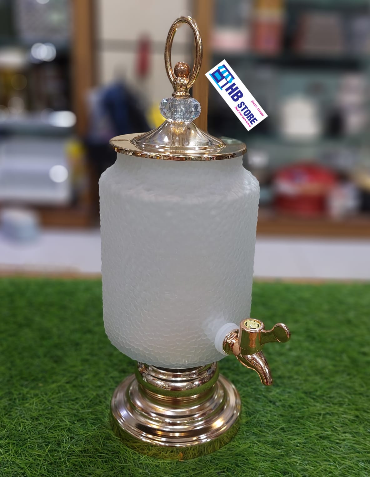 Juice dispenser - glass jug with faucet on a gold base